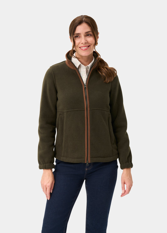 Woman in Aylsham Ladies Fleece Jacket in green, checked shirt, and blue jeans, smiling against a plain backdrop.