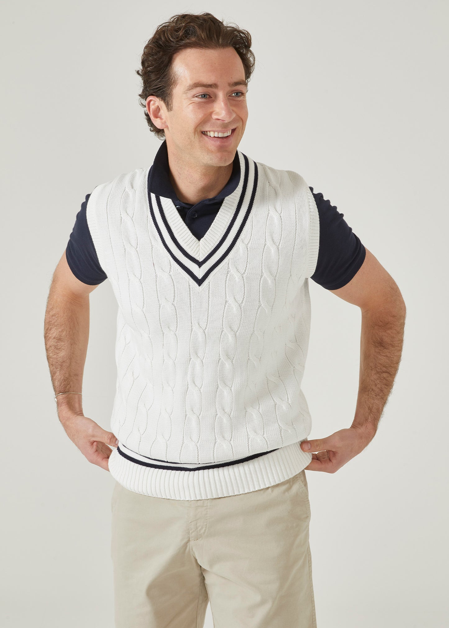 Cable knit slipover with an ecru base and dark navy trim.