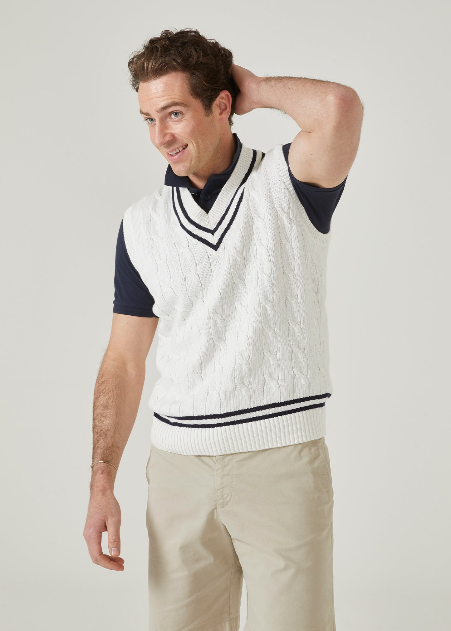Cable knit slipover with an ecru base and dark navy trim.