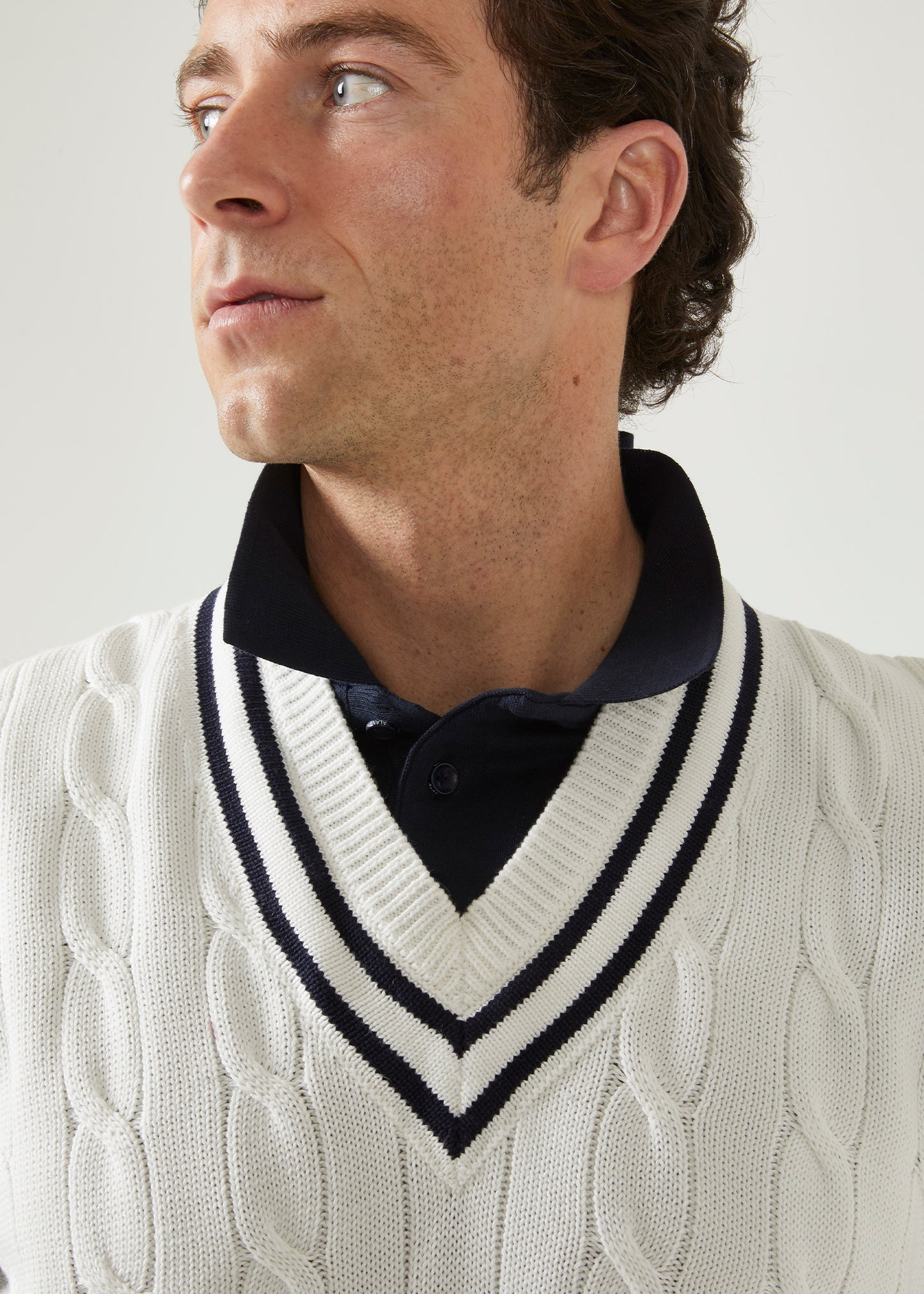 Cable knit slipover with an ecru base and dark navy trim.