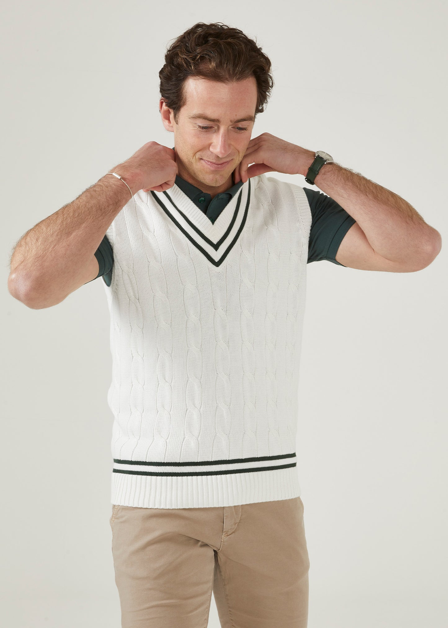 cable knit vee neck slipover in ecru with racing green trim.