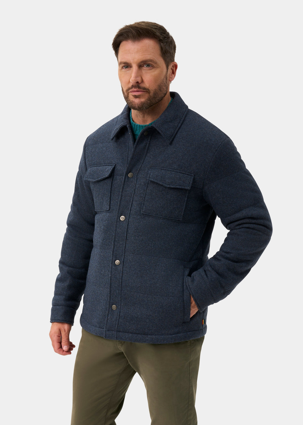 A man wearing a Richmond Men’s Knitted Quilted Shacket In Navy over a green sweater and olive trousers.