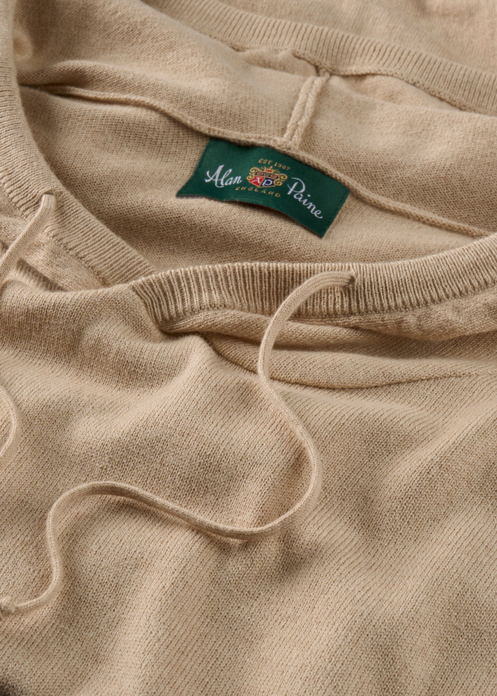 Close-up of Gaisby Cotton Merino Hoodie in Oatmeal, Regular Fit, with green Alan Paine label and drawstrings.