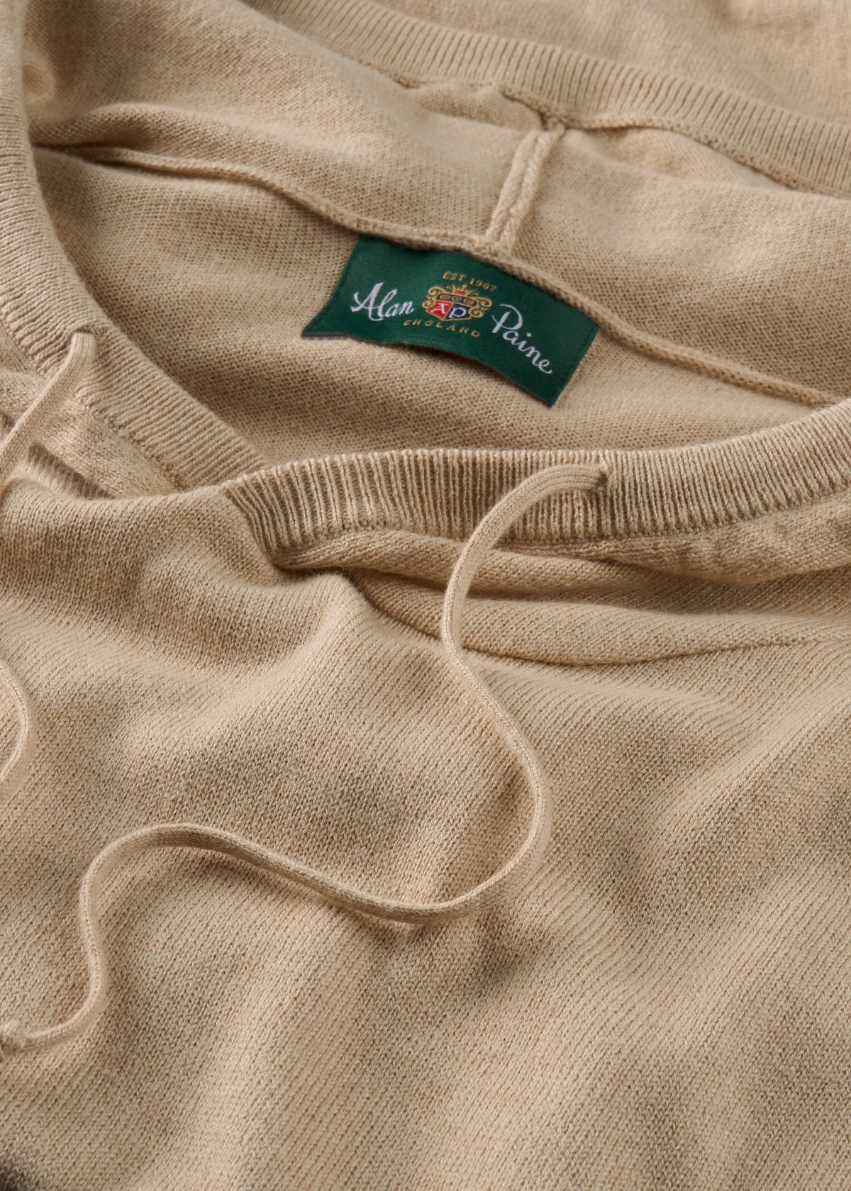 Close-up of Gaisby Cotton Merino Hoodie in Oatmeal, Regular Fit, with green Alan Paine label and drawstrings.