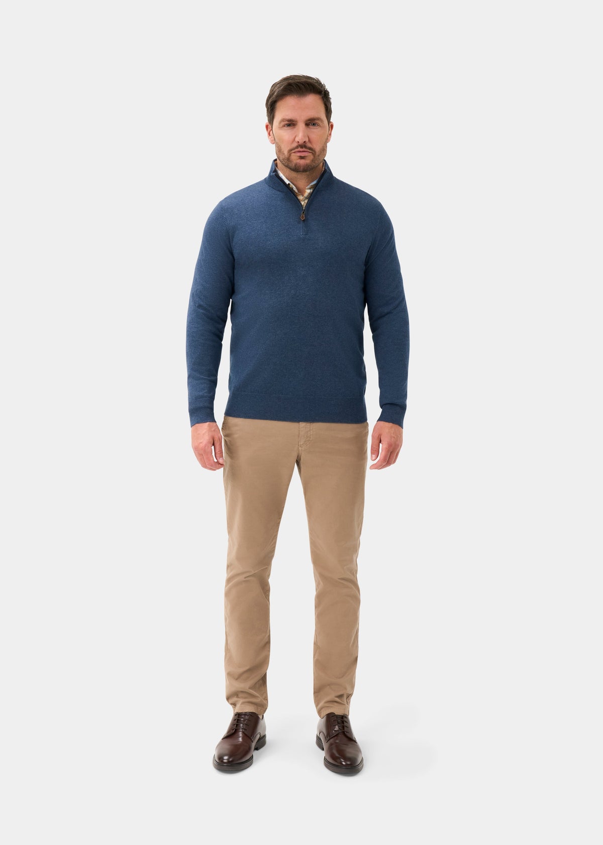 Man in Ashfield Cotton Merino Quarter Zip Jumper in Denim, khaki pants, brown shoes, on a white background.