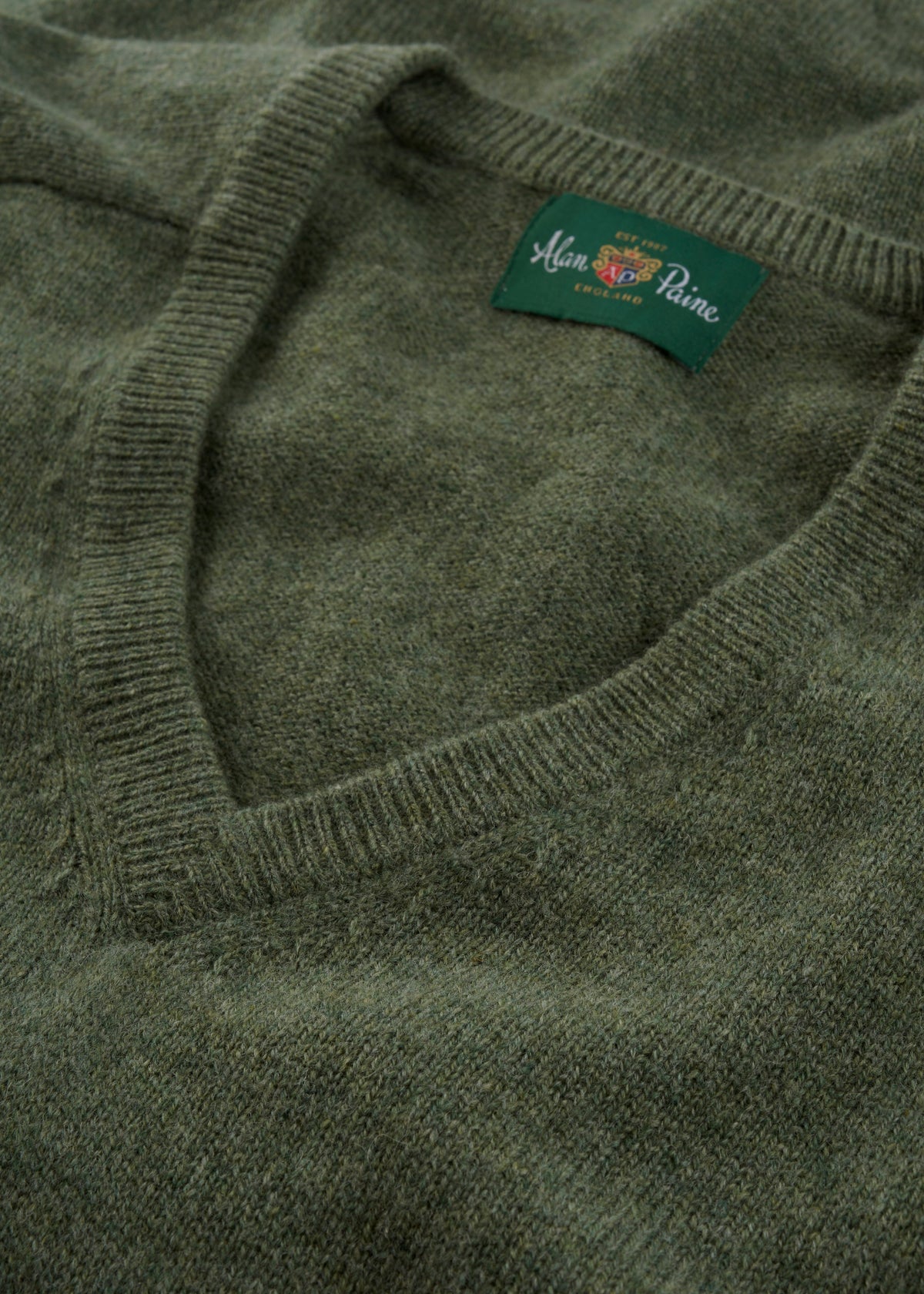 Close-up of the Hampshire Lambswool V-Neck Jumper in Landscape - Classic Fit, label visible inside collar.