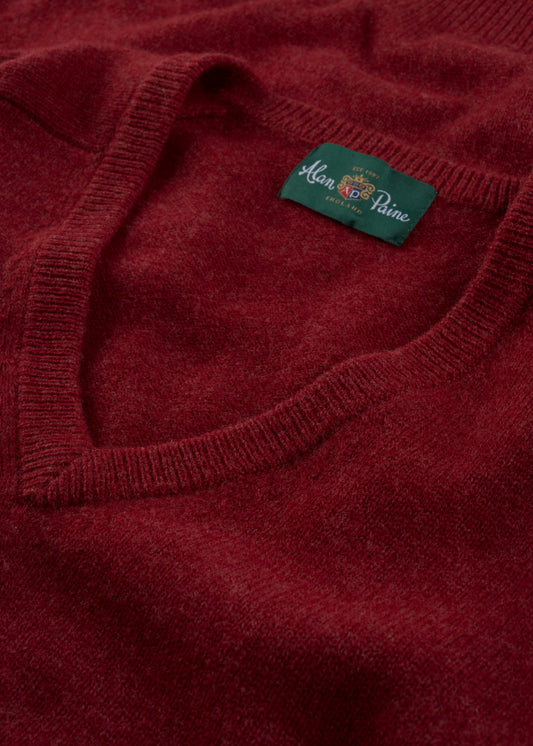 Close-up of a red Hampshire Lambswool Vee Neck Jumper in Poppy, classic fit, with green Alan Paine label at collar.