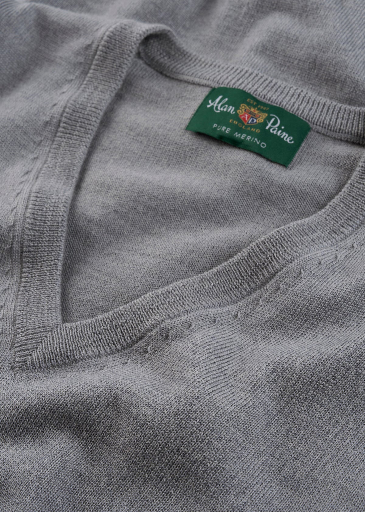 Gray sweater with a brand label on a close-up of the neckline.