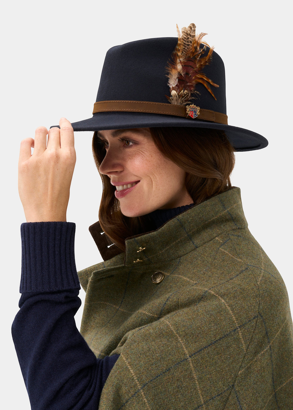 Richmond Unisex Felt Hat With Feather In Navy: a navy wool fedora with a brown band, small crest, and feathers.