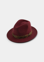 Ruby red felt fedora hat with a braided dark brown band and a medium brim.