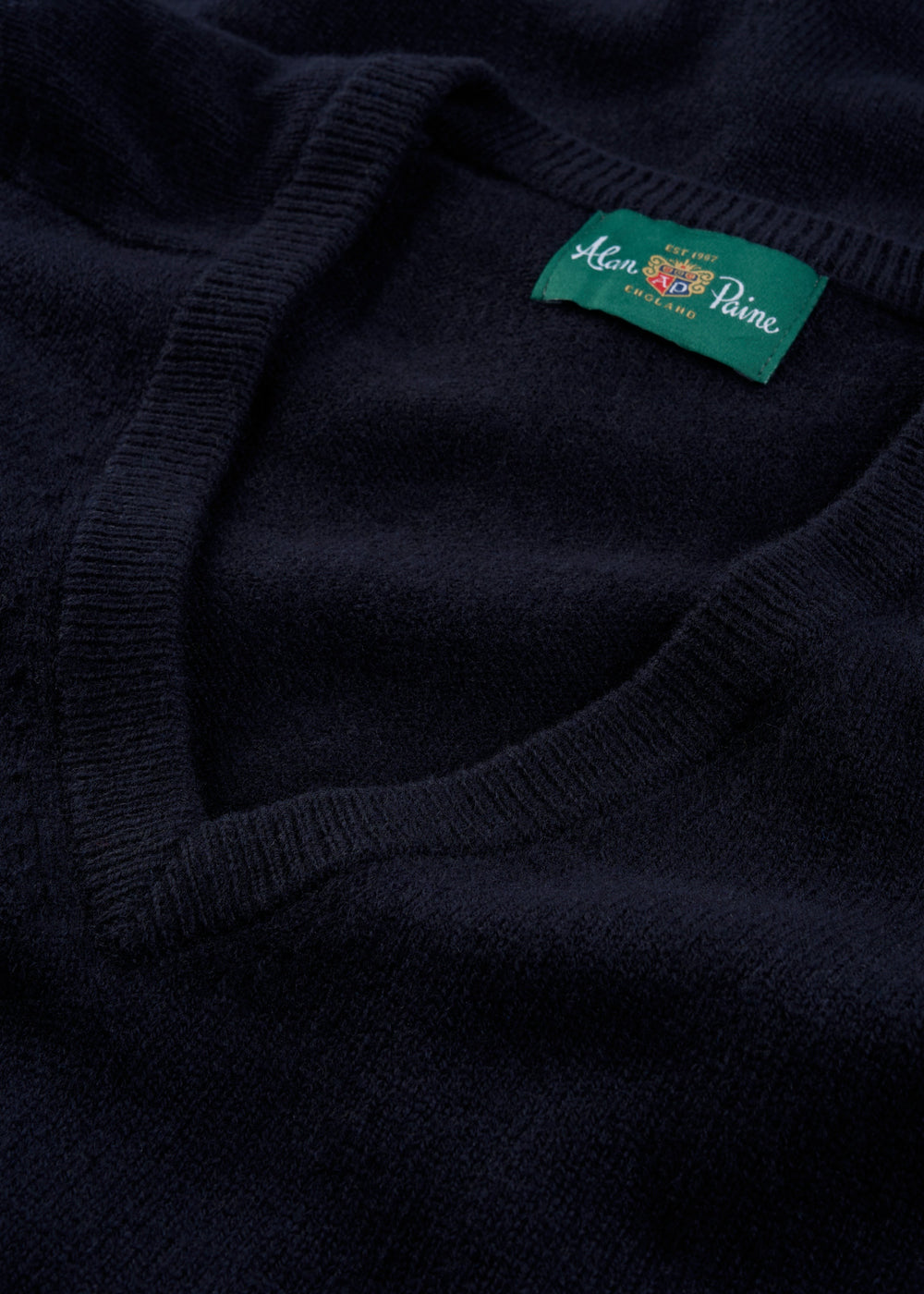 Alan Paine navy V-neck lambswool jumper featuring a ribbed neckline and branded interior label