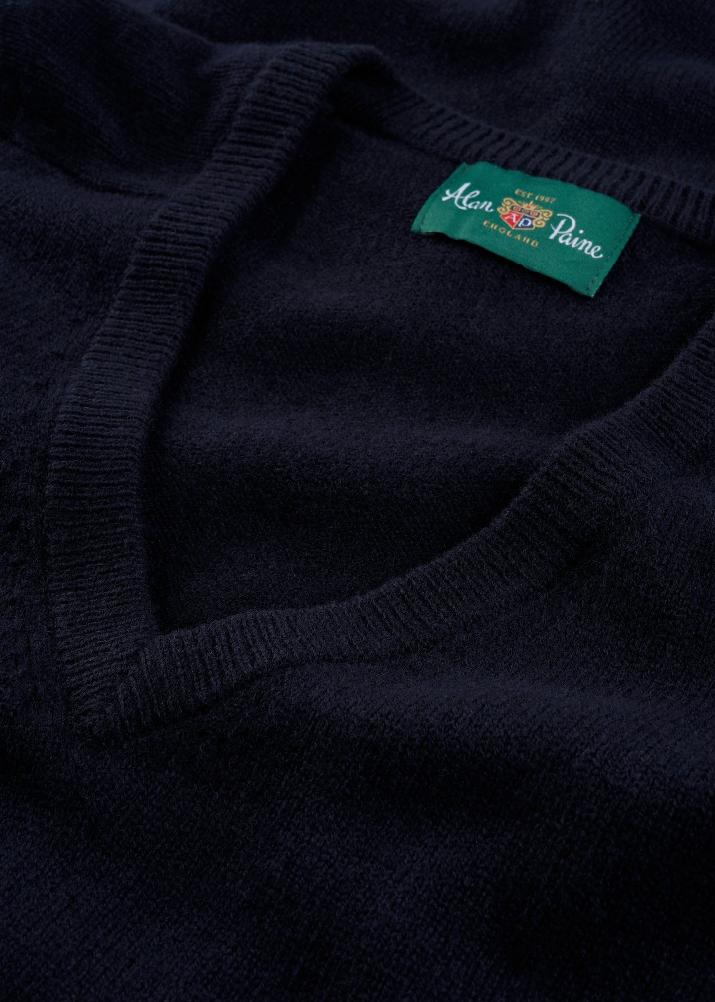 Alan Paine navy V-neck lambswool jumper featuring a ribbed neckline and branded interior label