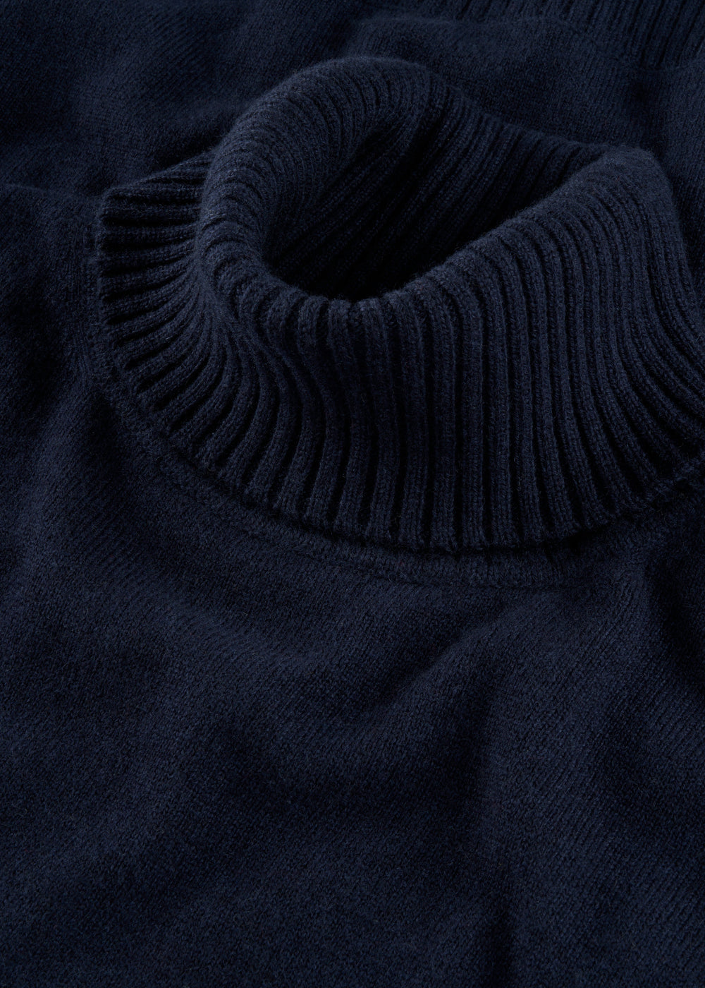 Close-up of Alexa Wool & Cashmere Roll Neck Jumper in Dark Navy, ribbed collar detail, laid flat.