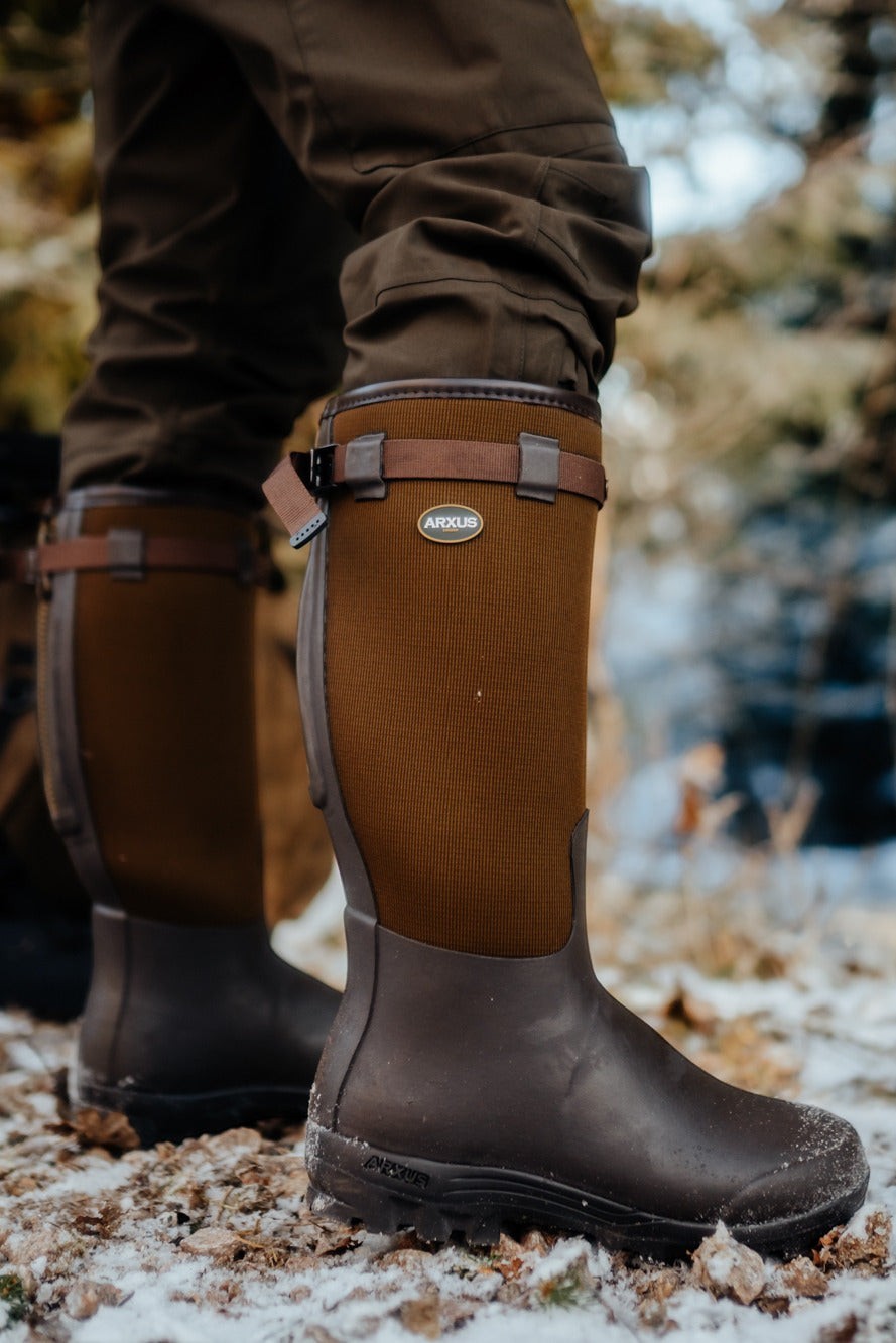 Person in Arxus Primo Nord LW Wellington Boots stands on a leafy ground wearing insulated pants.