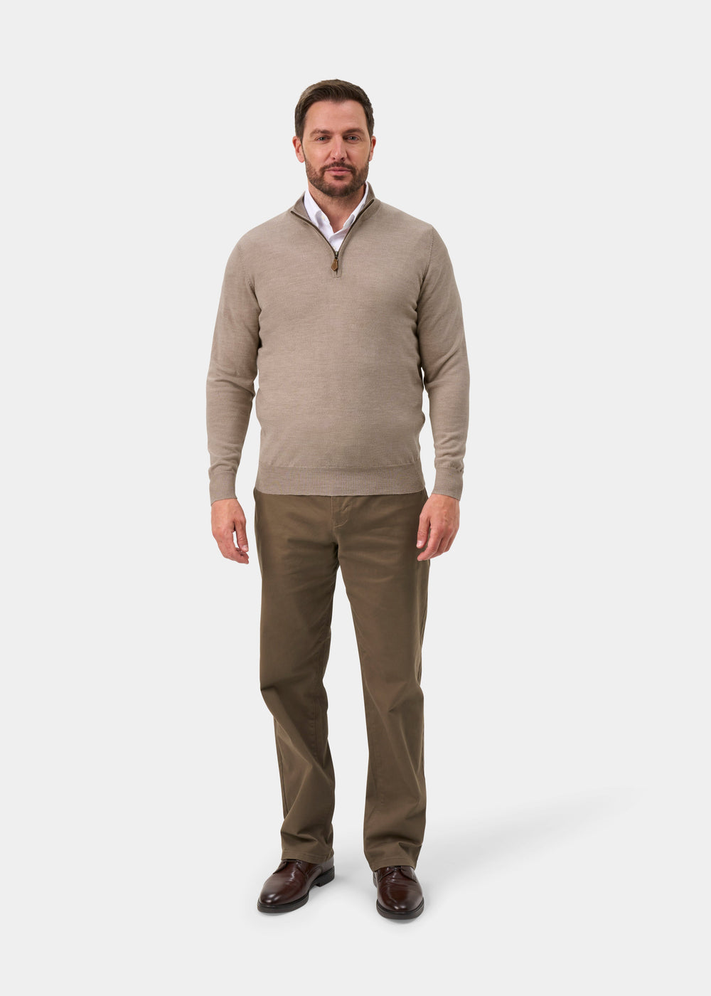 Man in Barton Merino Wool Quarter Zip Jumper in Cobble, white shirt, brown pants, and dark shoes.