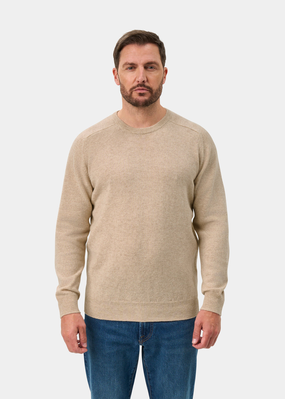 Model wears Dorset Lambswool Crew Neck Jumper in Linen, Classic Fit, with blue jeans against a plain white background.