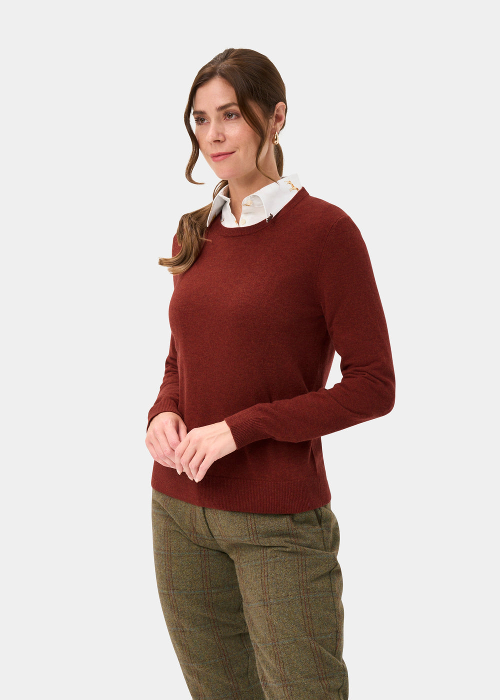 Woman in Ivy Wool & Cashmere Crew Neck Jumper in Autumn, over a white shirt with plaid trousers, plain background.