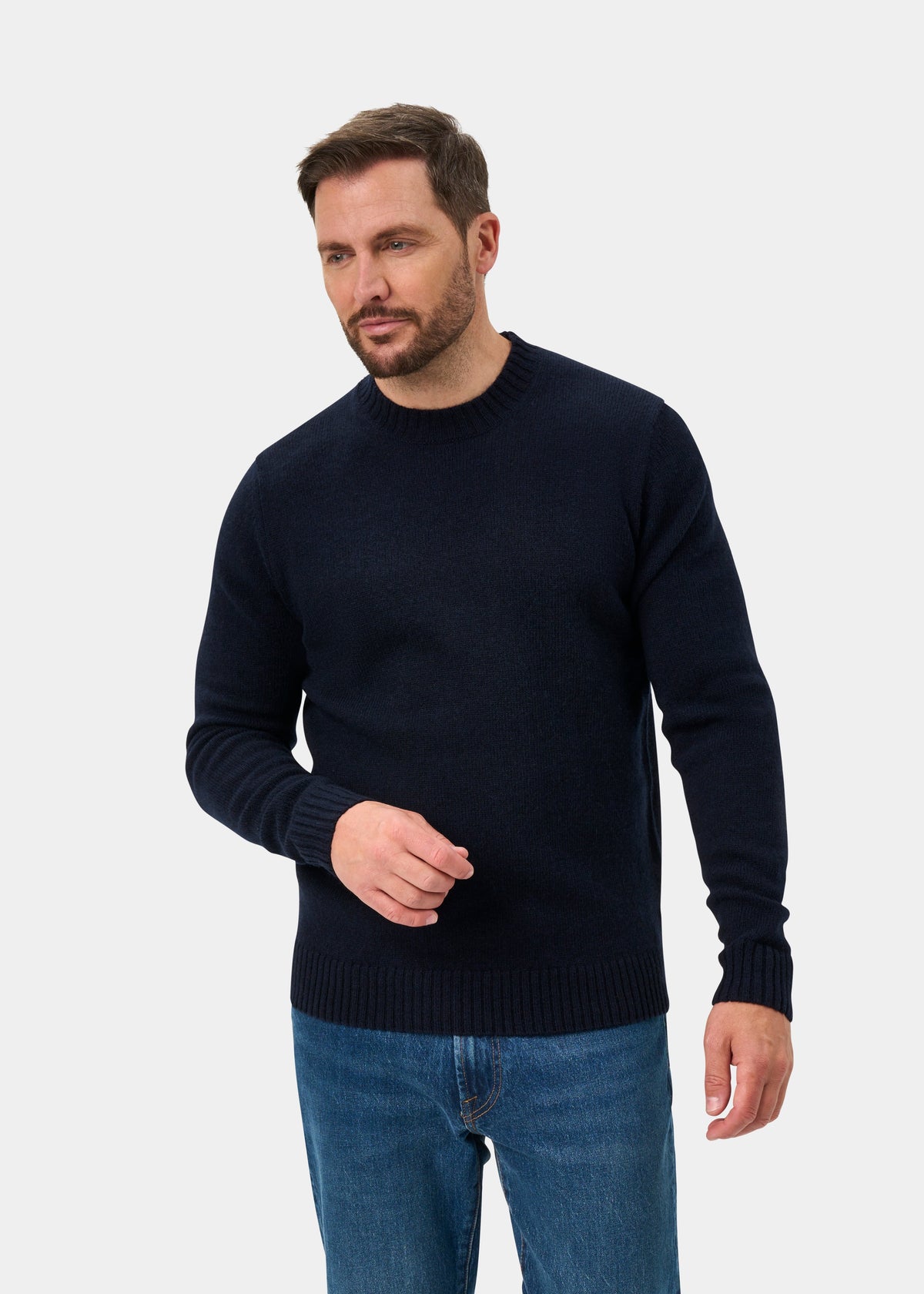 Man in Kinnadie Supersoft Shetland Wool Crew Neck Jumper (Concord, Regular Fit) and blue jeans on white backdrop.