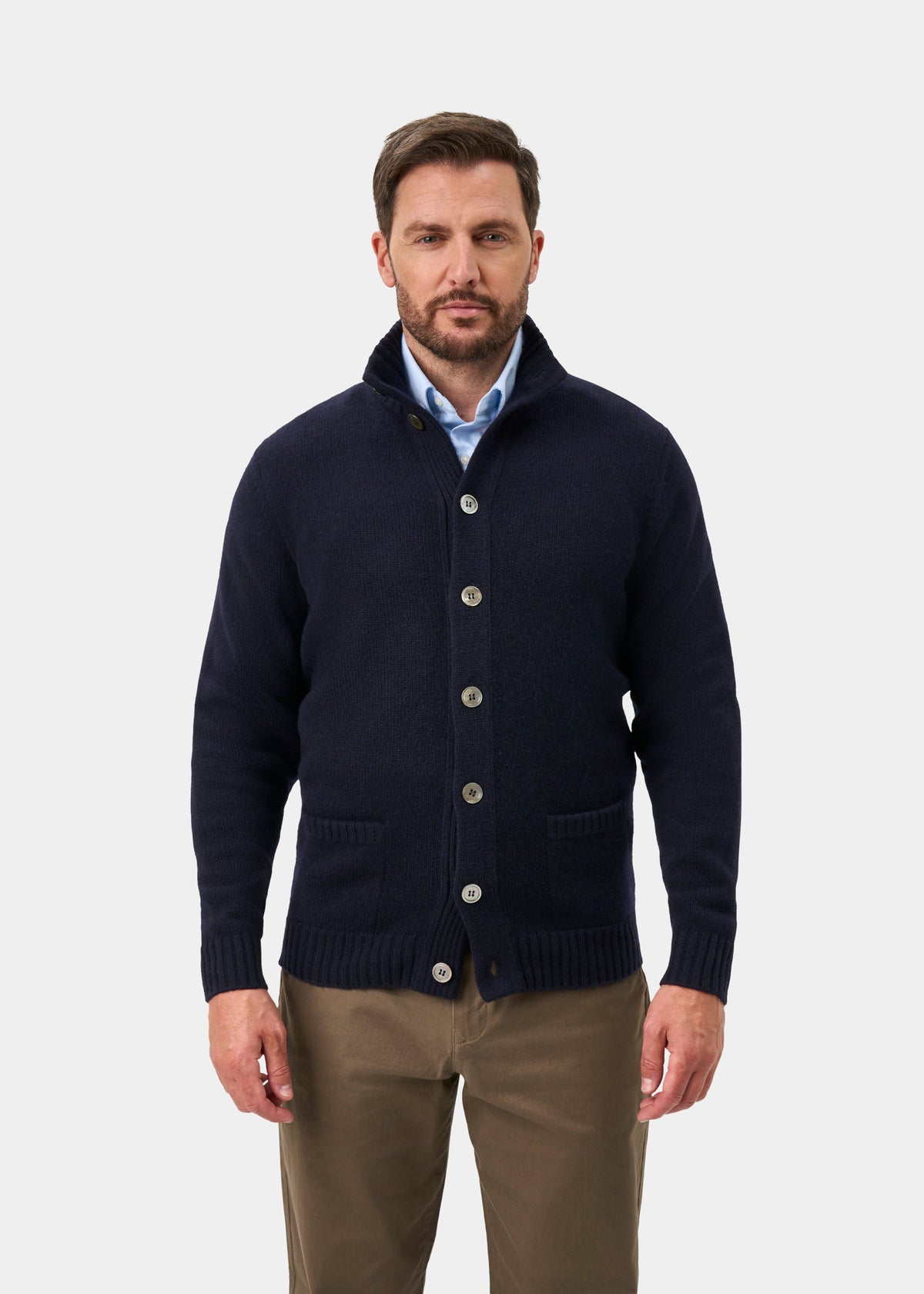 Man in a navy Landford Lambswool Mock Neck Jumper, light blue shirt, and khaki pants against a white background.