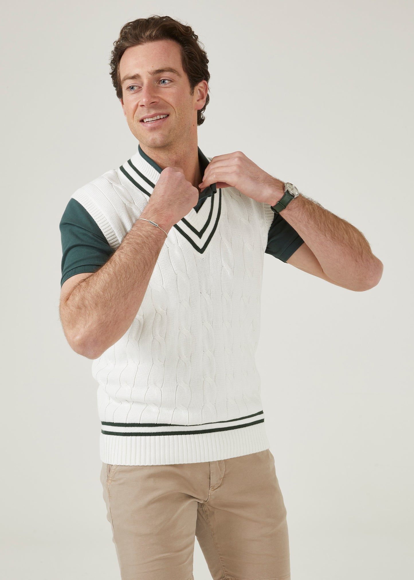 cable knit vee neck slipover in ecru with racing green trim.