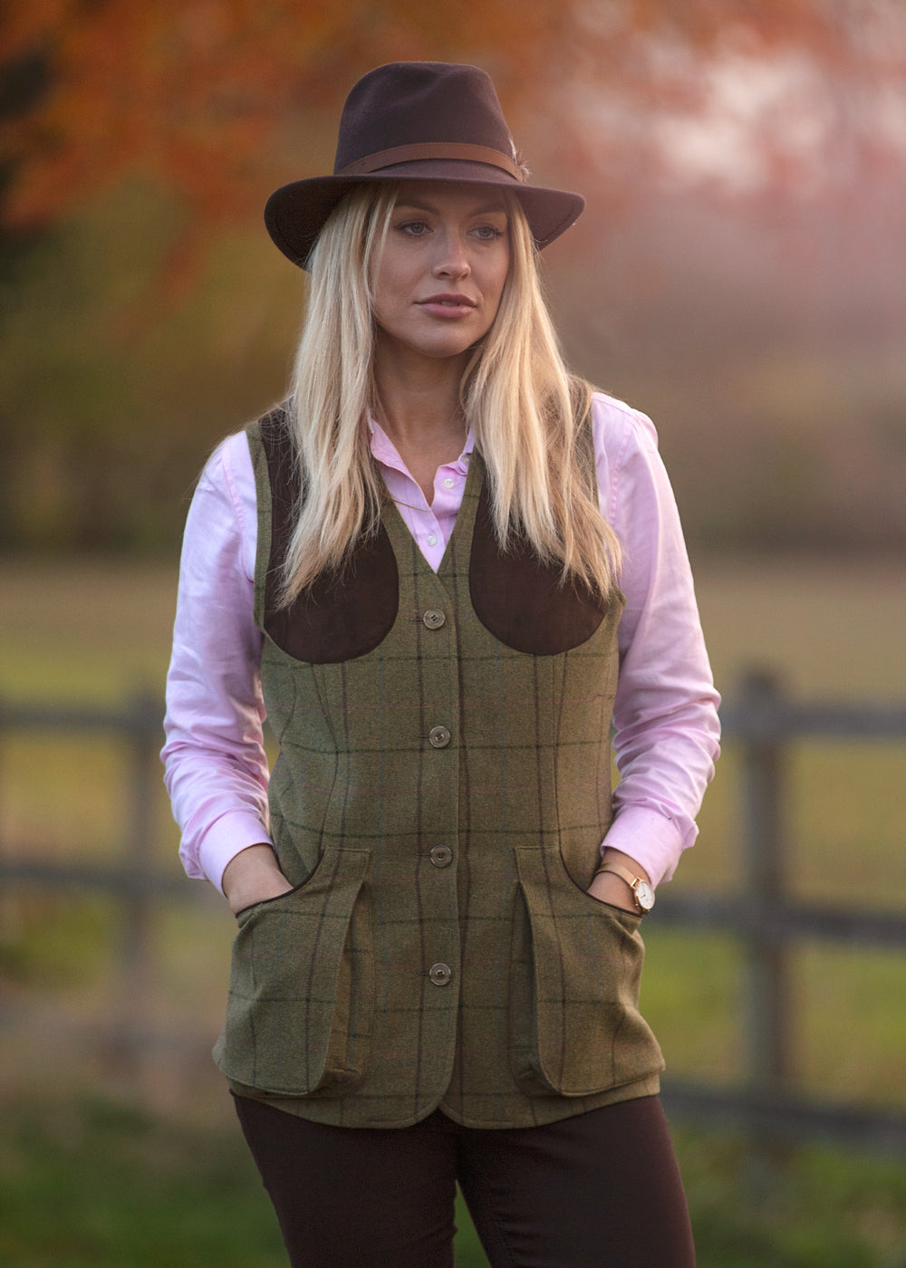 Felt fedora hat in deep brown with a leather decorative band, shown worn outdoors in soft light